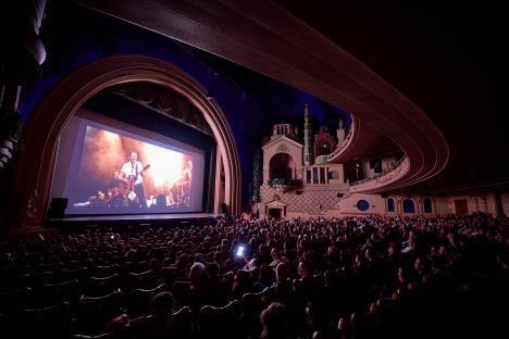 Audience watching a concert film in a large theater.