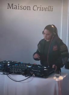 Woman DJing at Maison Crivelli event.