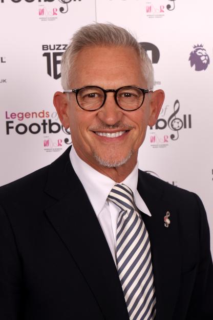 Gary Lineker smiling while wearing a suit and striped tie.
