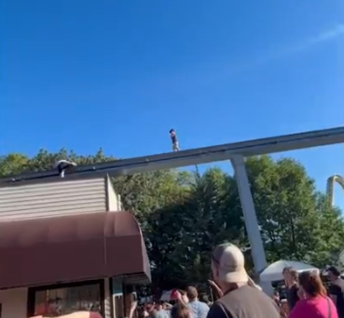 Person walking on top of a roller coaster track.