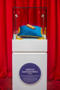 Greggs Sausage Roll displayed in a glass case at Madame Tussauds London.