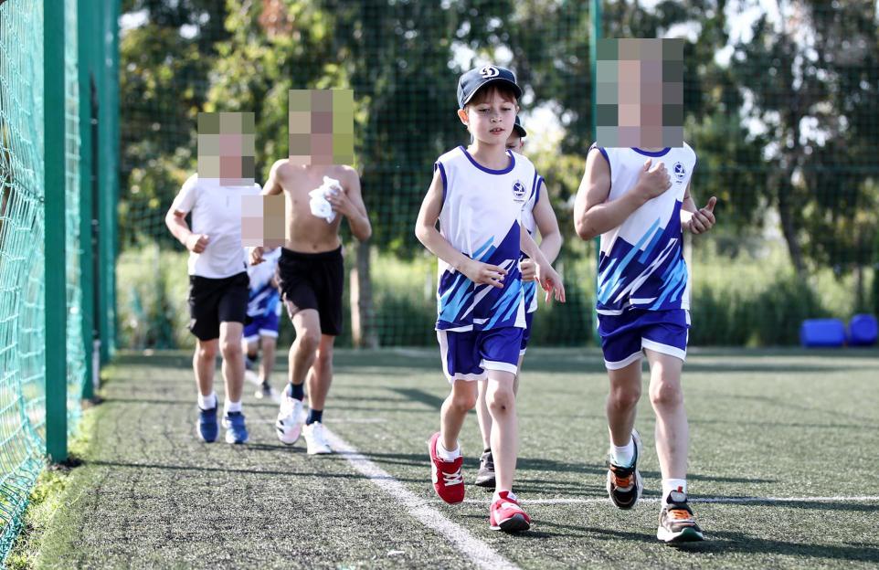 Boys jogging on a sports field; one is Vladimir Putin's son.