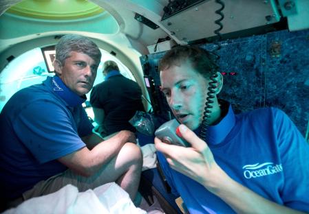 Submersible pilots communicating inside a submersible.