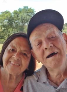 Photo of an elderly couple smiling for a selfie.