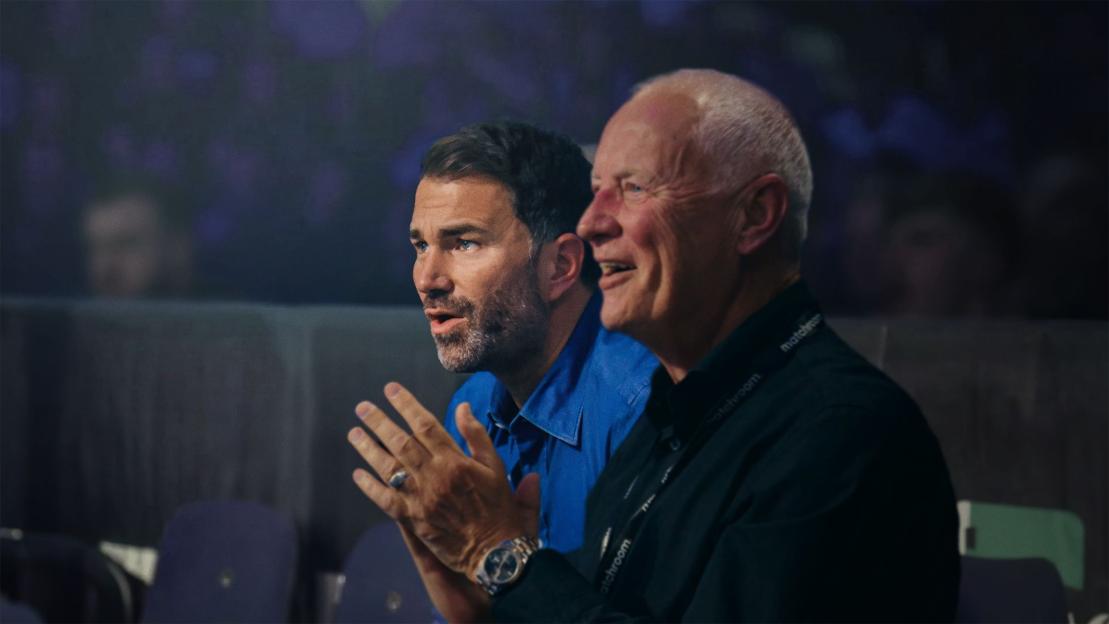 Eddie Hearn and Barry Hearn watching an event.