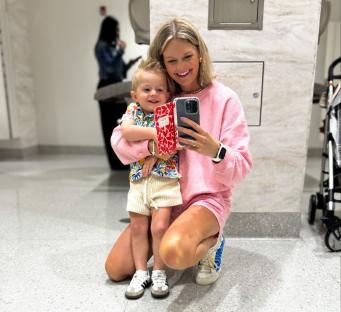 Woman and toddler taking a selfie in a restroom.