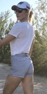 Woman in white shirt and patterned shorts, viewed from behind.