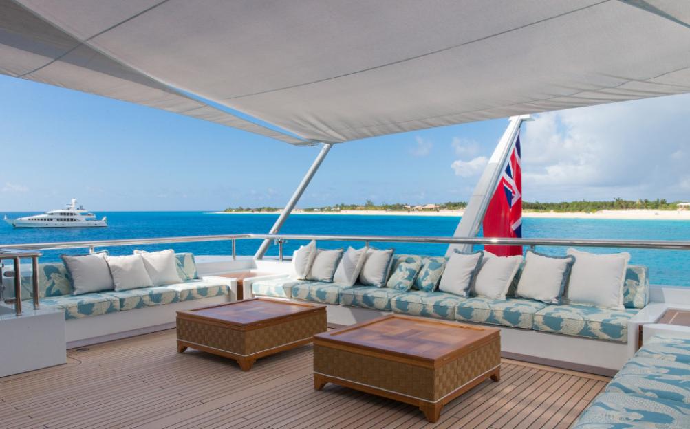 Elysian superyacht deck with seating and a British flag.