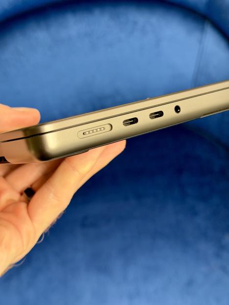 The side of a gray MacBook Pro, showing a MagSafe port, two USB-C ports, and a headphone jack.
