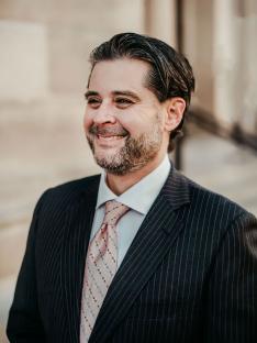 Portrait of a man in a pinstripe suit.