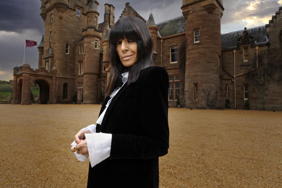 Claudia Winkleman posing in front of a castle.