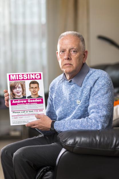 Kevin Gosden holding a missing person poster for his son, Andrew Gosden.