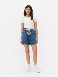 Woman wearing denim Bermuda shorts with rope tie.