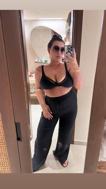 Lauren Goodger in a black bra and wide-leg pants.