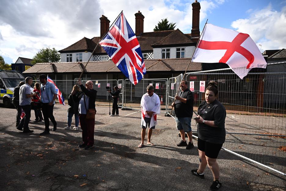Protestors holding British flags outside a hotel housing asylum seekers.