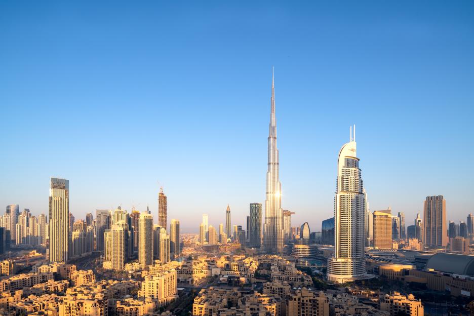 Aerial view of Dubai skyline at sunrise.