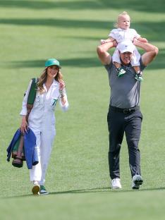 Brooks Koepka walking with his wife and son.