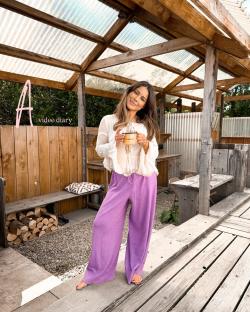 Woman holding a mug in a wooden structure.