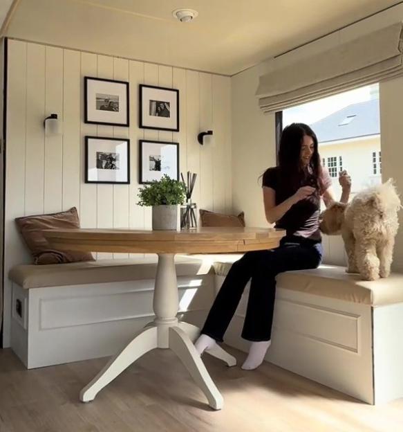 Woman with dog in renovated static caravan.