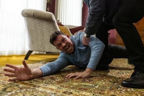 A man is being restrained on the floor.
