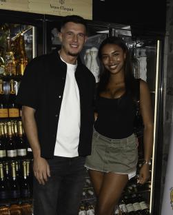 Two Love Island stars posing together at a bar.