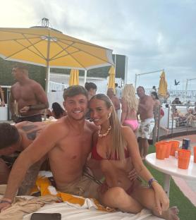 Nicole Samuel and a man posing together at a pool party.