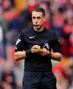 Photo of David Coote, a former Premier League referee, writing on a yellow card.