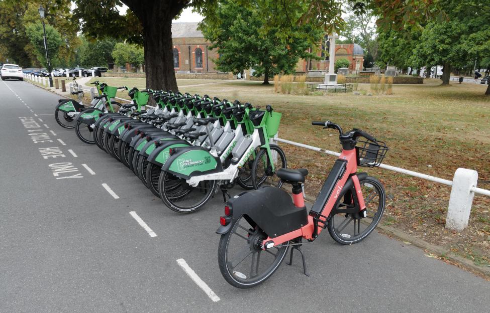Lime and Voi e-bikes parked near a church.