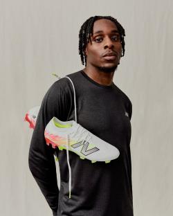 Jeremie Frimpong holding New Balance football boots.