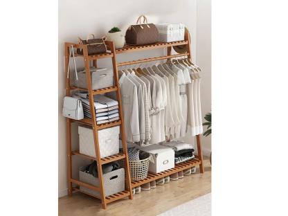 Bamboo garment rack with shelves and clothing.