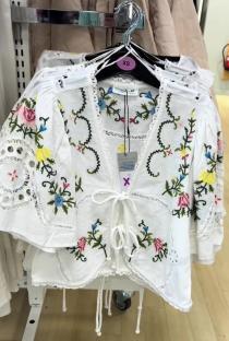 White embroidered top with floral details.