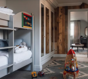 Child's bedroom with bunk bed, toys, and built-in wardrobe.