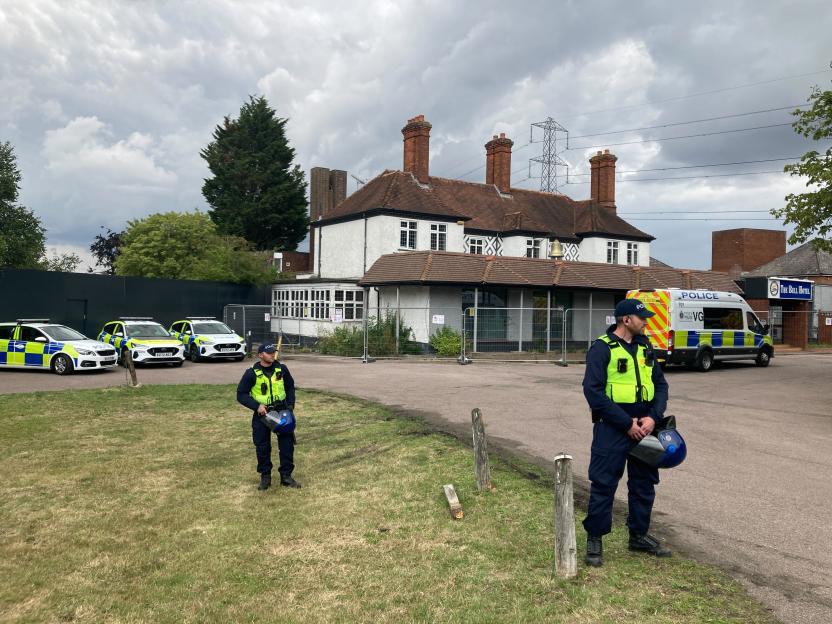 Police officers outside the Bell Hotel in Epping during a protest.