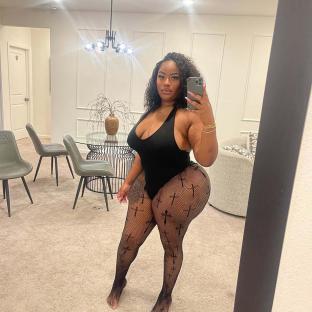 Woman in black bodysuit and cross-patterned tights taking a selfie.