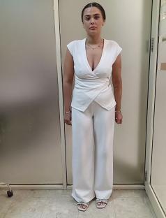 Booking photo of Charlotte May Lee in a white pantsuit.