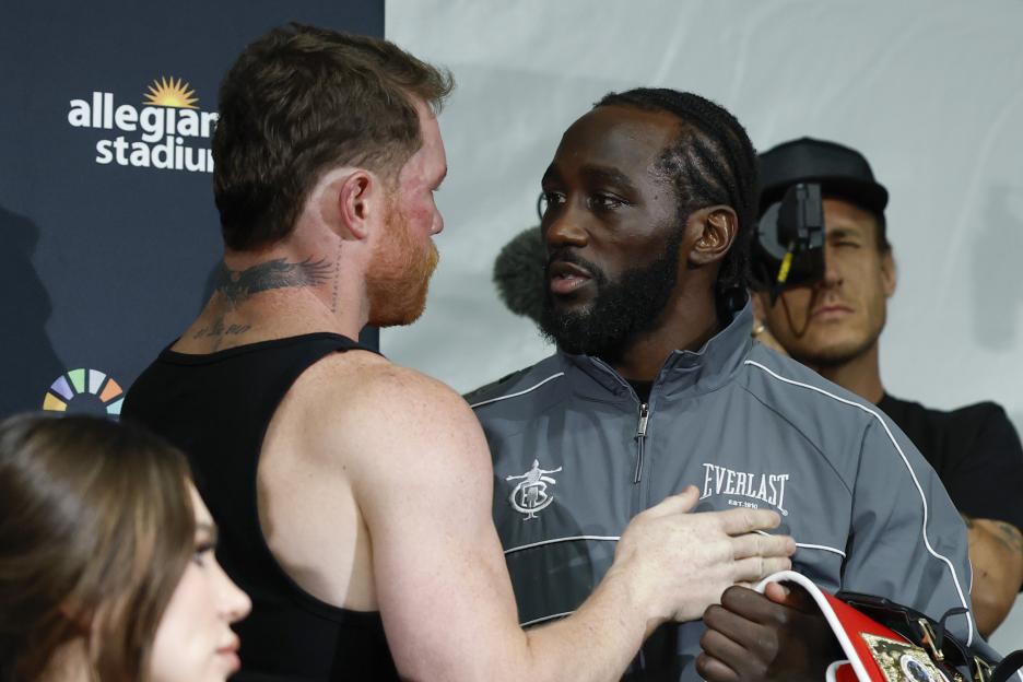 Canelo Alvarez and Terence Crawford embracing after a boxing match.