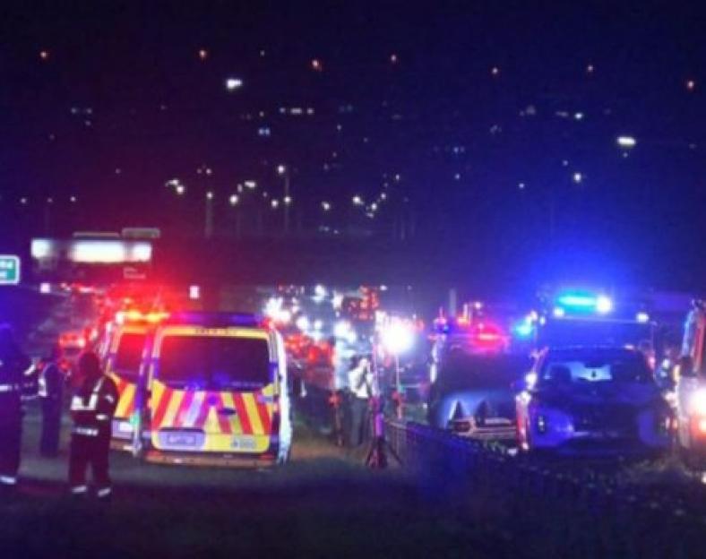 Emergency vehicles at a freeway accident scene at night.