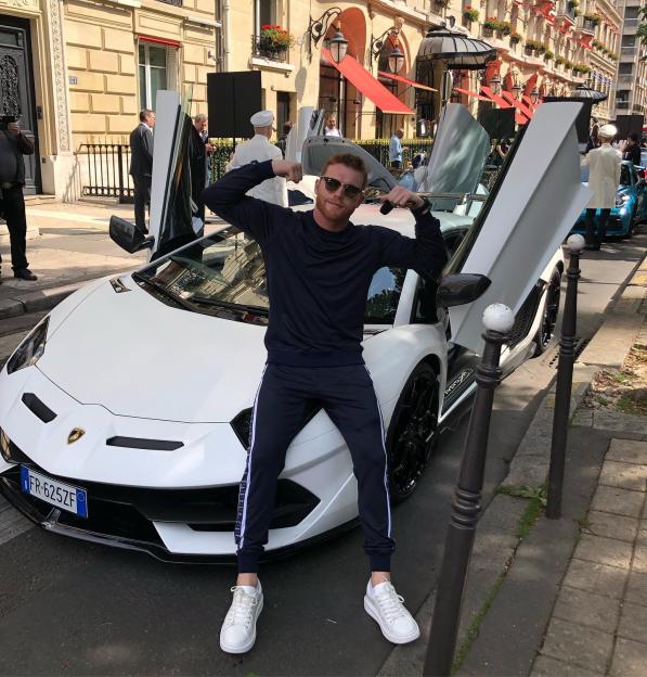 Canelo Álvarez posing with a white Lamborghini.