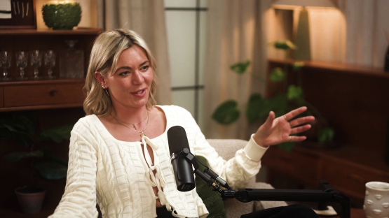Woman speaking into a microphone during a podcast interview.
