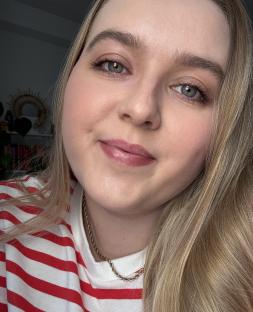 Close-up selfie of a woman with blonde hair wearing a red and white striped shirt.