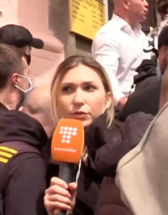 Reporter holding microphone during interview.