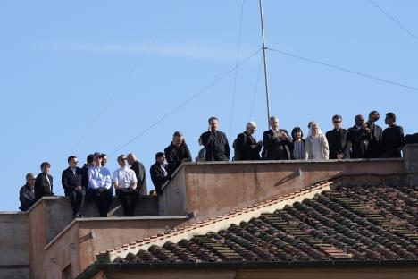 Clergy on a rooftop terrace awaiting the papal conclave results.