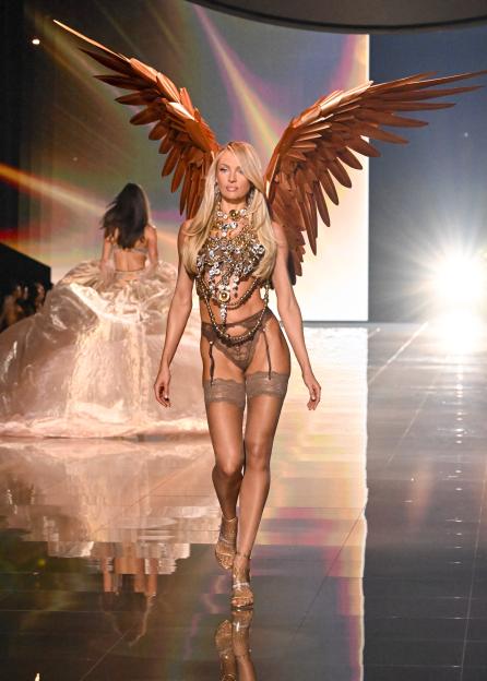 Candice Swanepoel modeling a brown lingerie set with large gold wings at the Victoria's Secret Fashion Show.