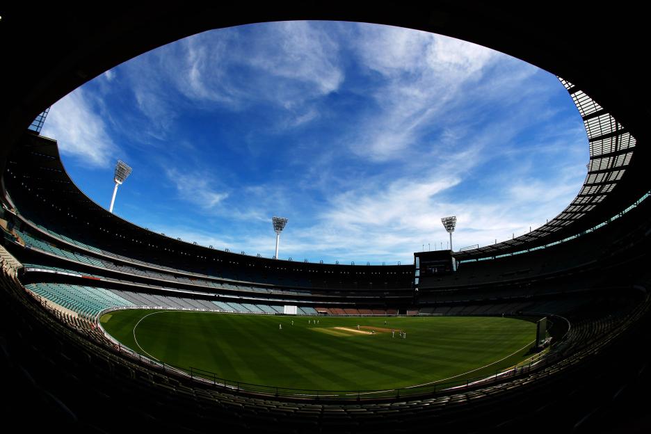 A fish-eye view of the Melbourne Cricket Ground with a cricket match in progress.