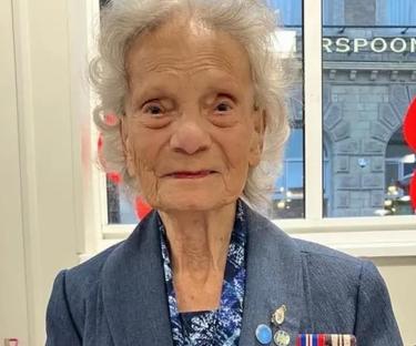 Portrait of a smiling elderly woman wearing medals.