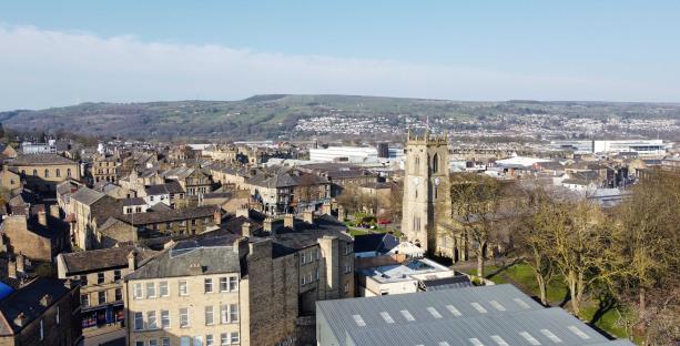 Aerial view of Dewsbury, UK, showing the town center and surrounding hills.