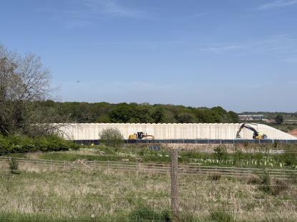HS2 construction site with large concrete wall and machinery.