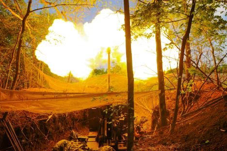 Ukrainian servicemen firing a howitzer.