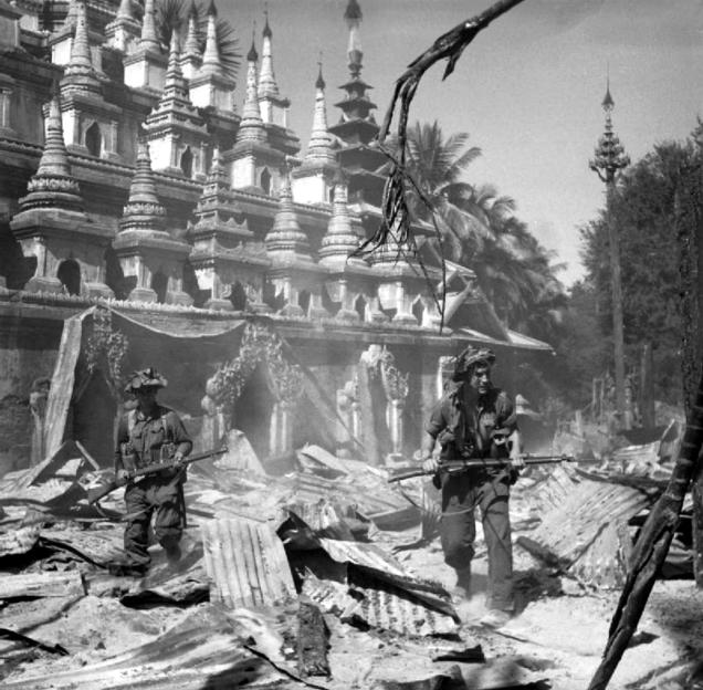 World War II photo: Soldiers walking through rubble near a damaged pagoda in Burma.
