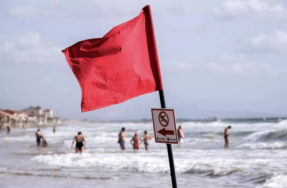 Red flag and no swimming sign on a beach.